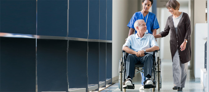 nurse pushing man in wheelchair